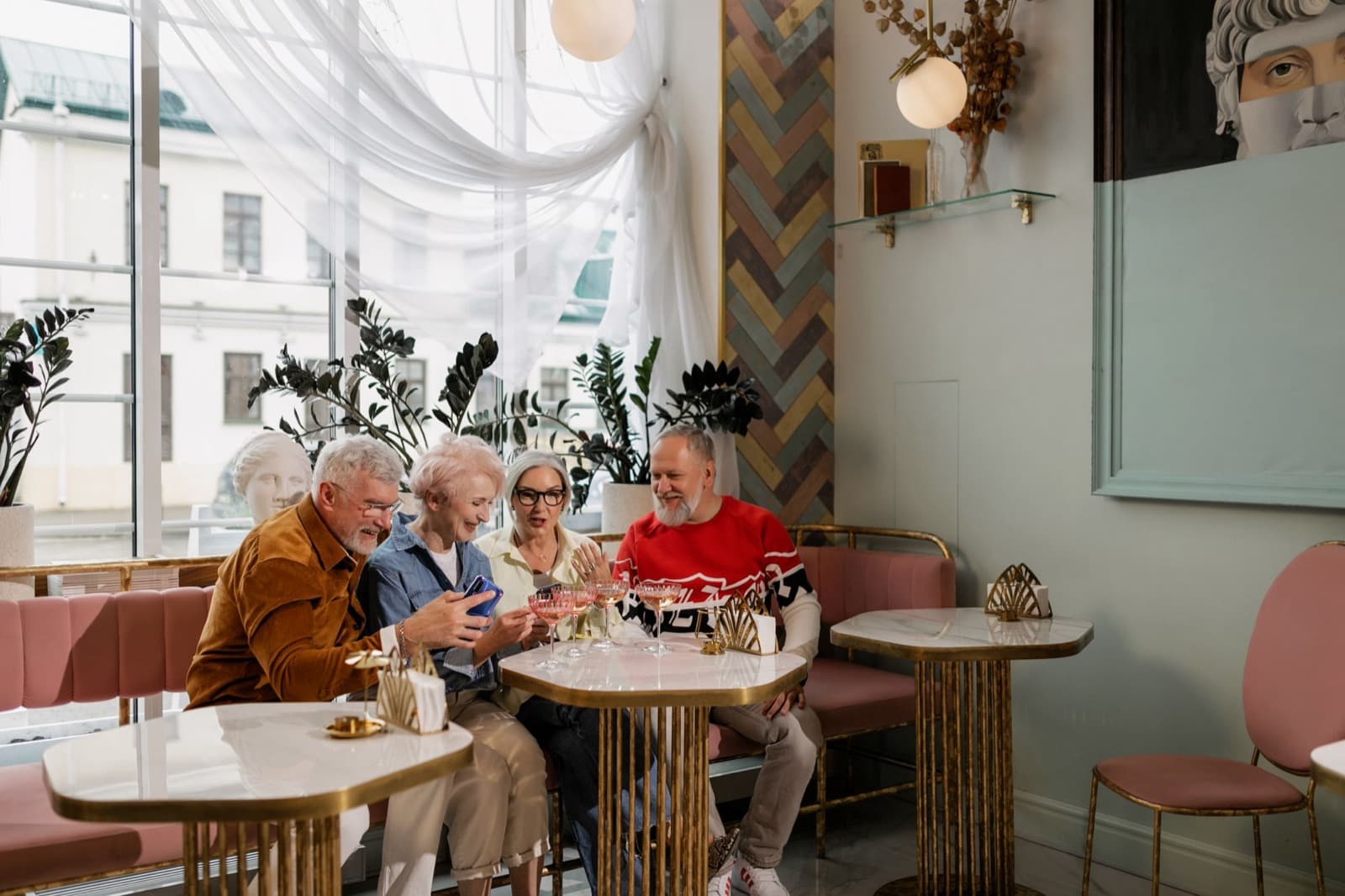 A small group of people sit laughing together at a cafe table