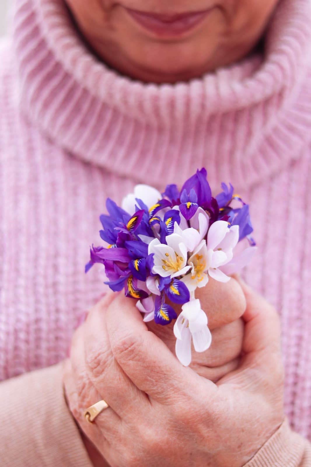 A woman holds a small bunch of spring flowers in her hands